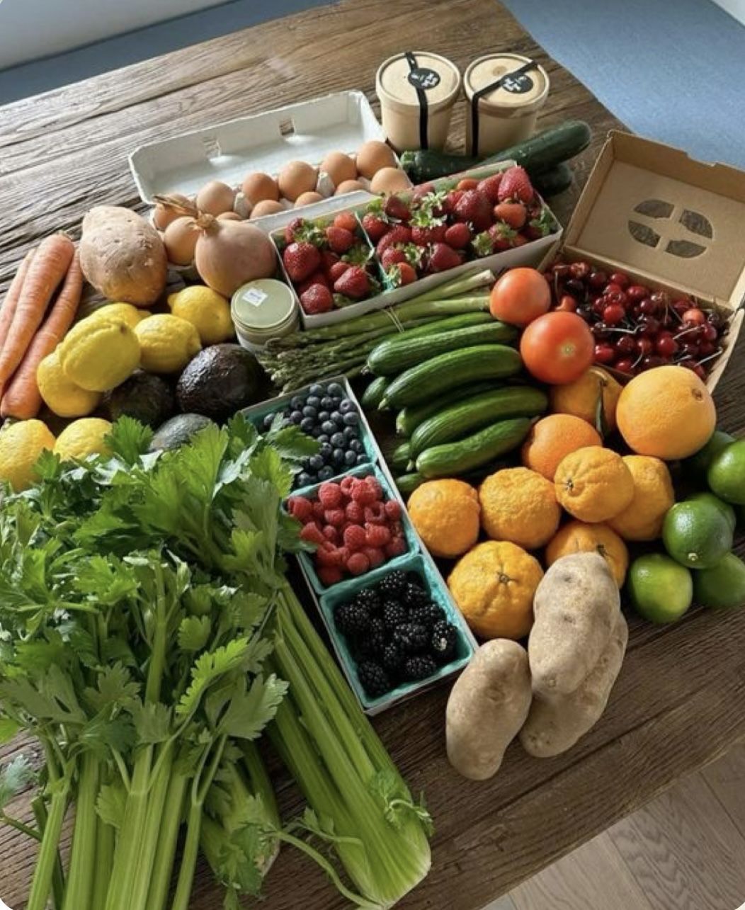 Assortiment de fruits, légumes et produits frais sur une table en bois, idéal pour une alimentation saine et équilibrée.